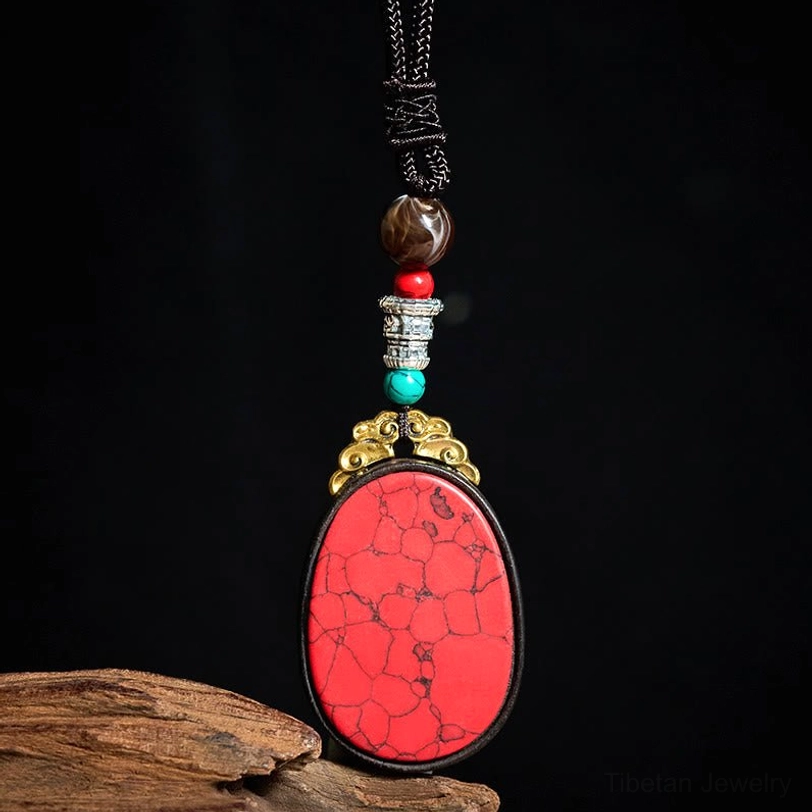 Red cracked stone ebony wood tribal necklace with decorative beads, oblique hanging view