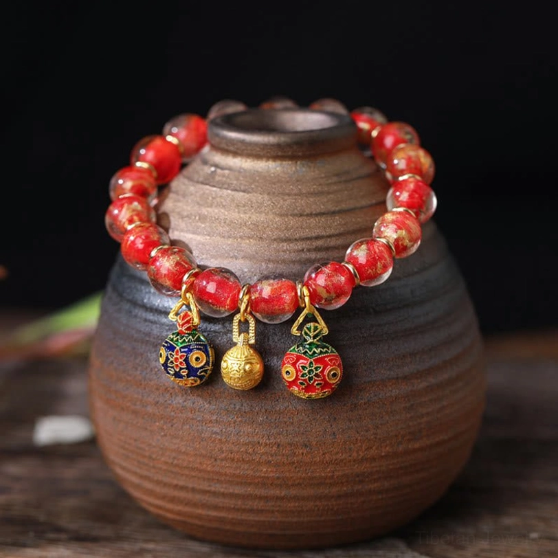 Red gradient liuli glass bead bracelet with gold swallowing beast charm close-up