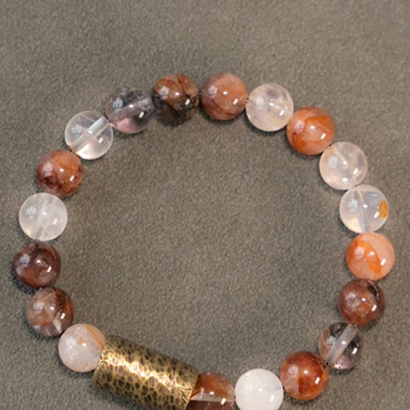 Woman wearing red hematoid quartz bracelet on wrist, lifestyle photography showing spiritual healing jewelry