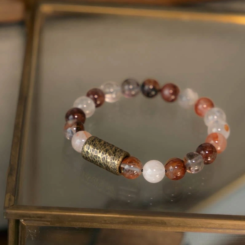 Red hematoid crystal protection bracelet displayed flat, showing rich red mineral inclusions in clear quartz matrix