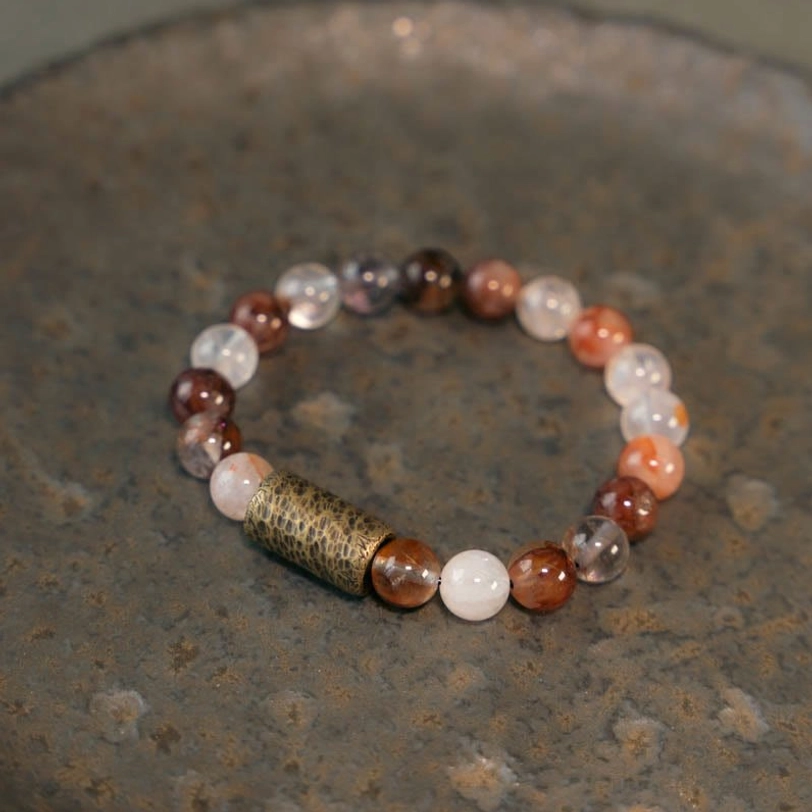 Red hematoid quartz beaded bracelet with gold-toned copper spacer, close-up detail of natural red inclusions