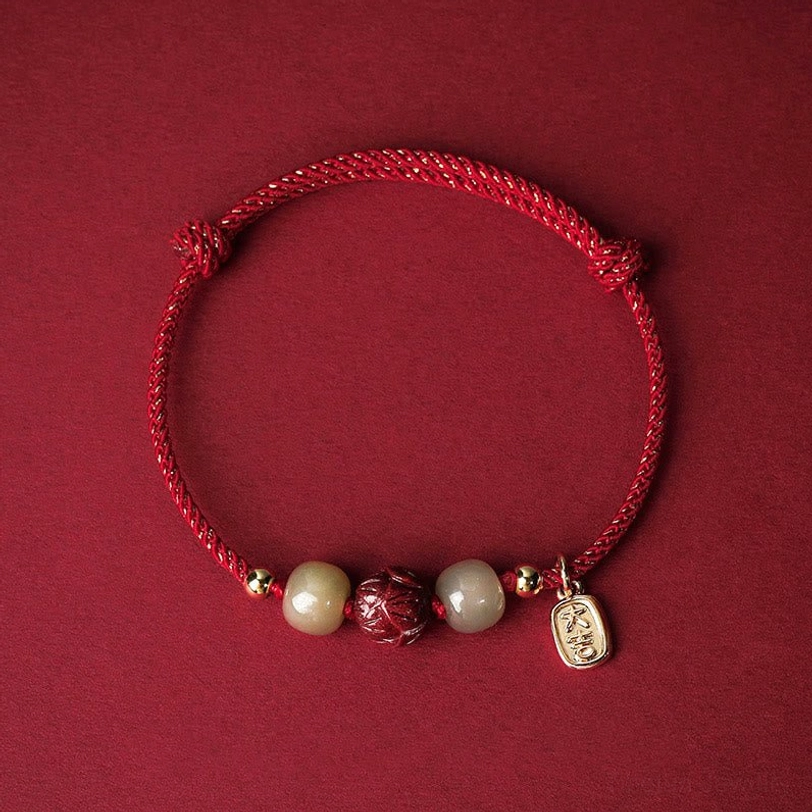 Red silk rope Hetian jade cinnabar lotus lucky bracelet with 14K gold plating, flat lay top-down view