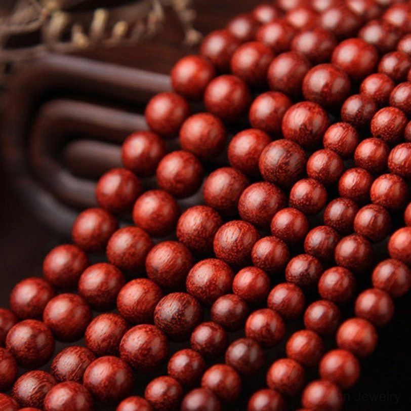Macro close-up of red sandalwood beads showing fine wood grain and uniform round shape, densely packed with natural wood texture visible