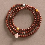 Red sandalwood small leaf triple wrap bracelet with sterling silver Fu character charm and mixed accent beads - top view flat lay
