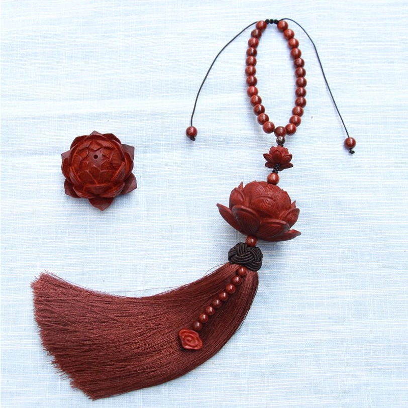 Complete Tibetan lotus tassel pendant with spare wooden lotus carvings and beaded trim components on blue fabric background