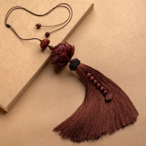Handcrafted red sandalwood lotus tassel pendant flat lay on kraft paper showing beaded strand and woven black decorative knot