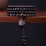 108 red sandalwood mala beads bracelet with lotus pendant and turquoise spacers overhead view