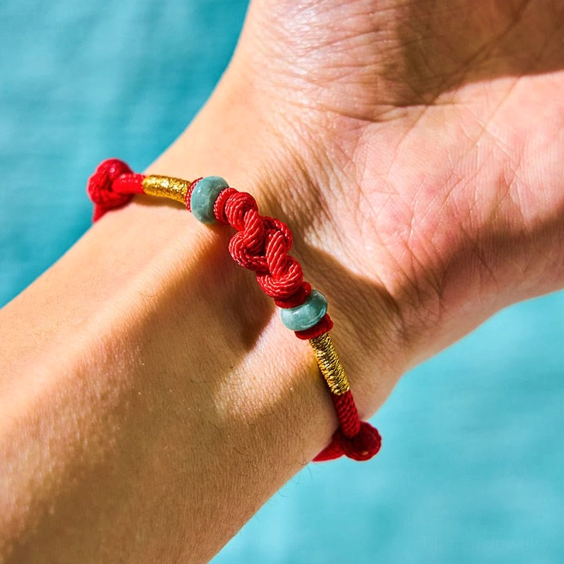 Red braided knot bracelet with twisted design and jade stone accents