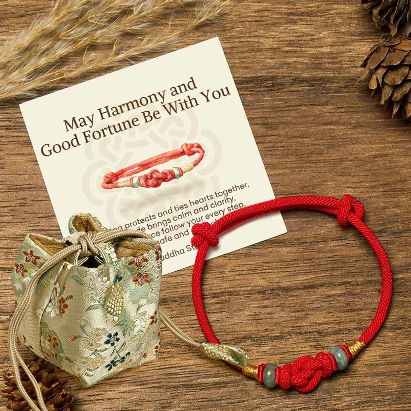 Red string jade bracelet with embroidered pouch and matching greeting card gift set on wooden desk