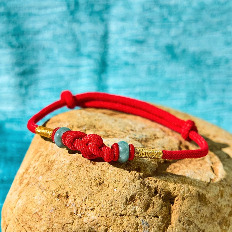 Braided red cord fortune knot with jade beads and gold wrapped sections