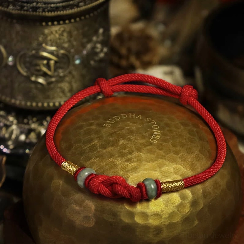 Adjustable red cord protection bracelet flat lay showing braided design and knotted closure