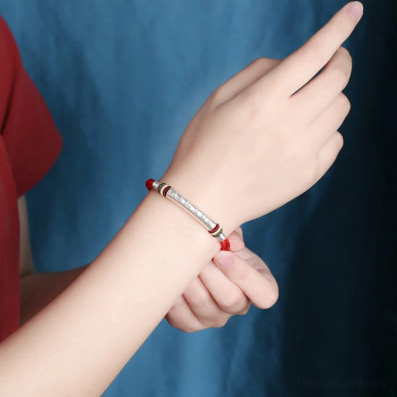 Sacred mantra bracelet worn on left wrist showing side view with silver tube detail and rope design