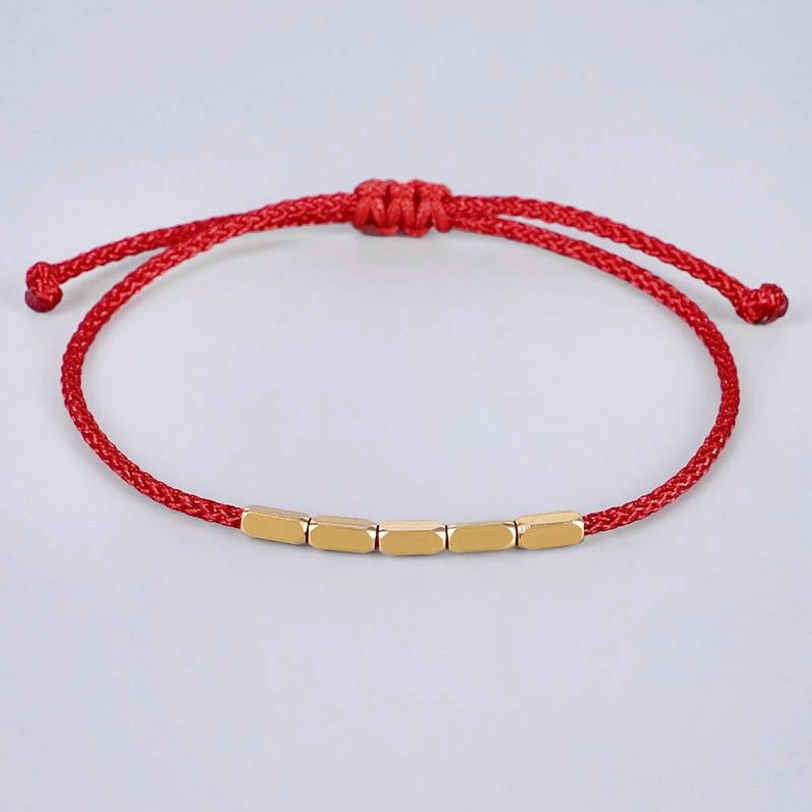 Single red Tibetan copper bead bracelet with adjustable sliding knot, showing rectangular copper beads and braided cord detail