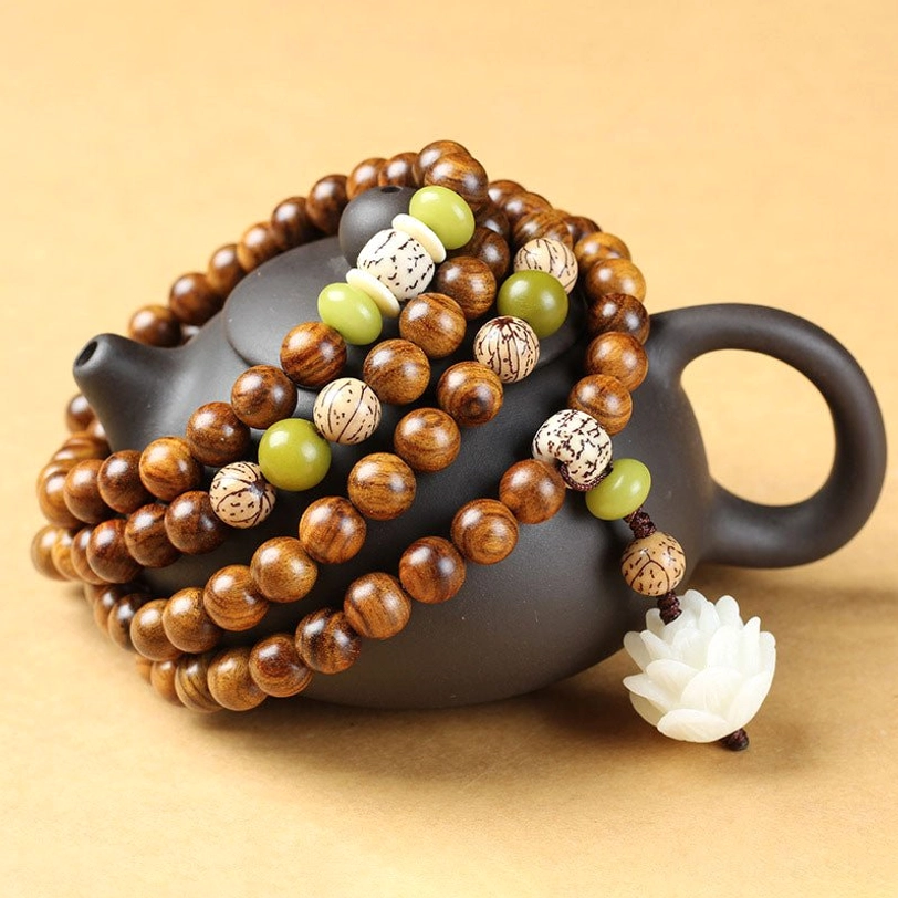 Tibetan rosewood lotus mala bracelet with 108 beads, 6mm 7mm 8mm sizes, displayed in flat lay with black ceramic teapot and wooden details