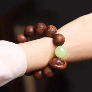 Rosewood tiger protection bracelet worn on wrist side view demonstrating fit and warm brown wood tone with carved details