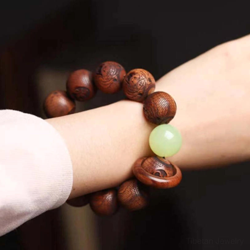 Rosewood tiger protection bracelet worn on wrist side view demonstrating fit and warm brown wood tone with carved details