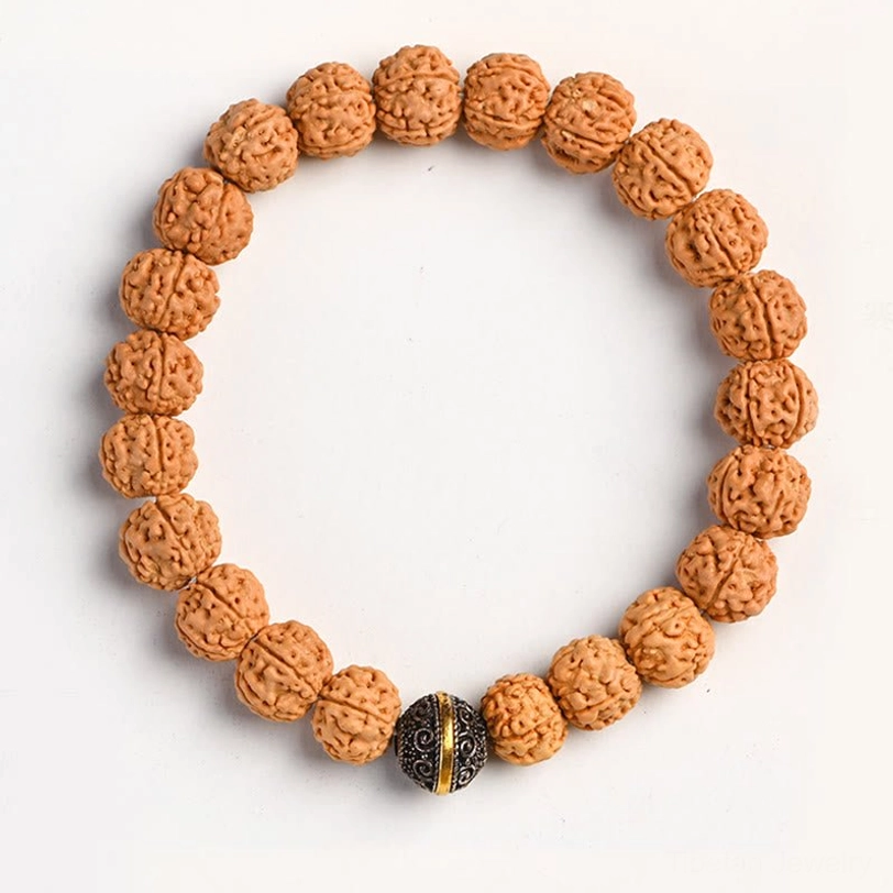 Single Rudraksha Bodhi seed spiritual bracelet with central Tibetan silver barrel bead on white backdrop