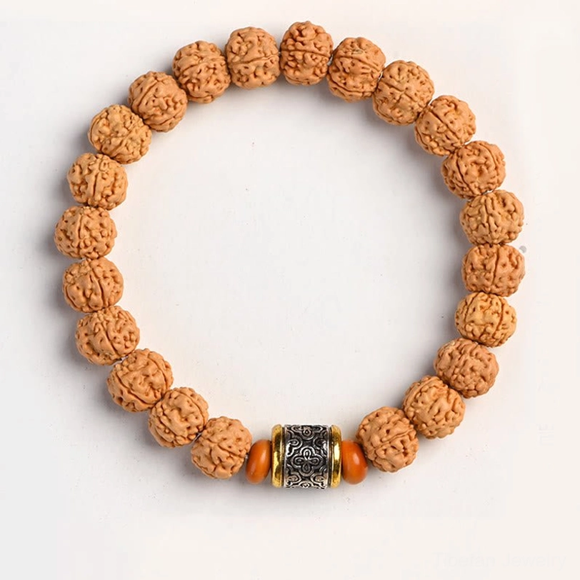 Rudraksha Bodhi bracelet with Tibetan silver barrel and orange spacer beads on white background