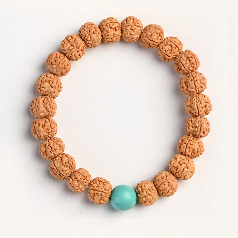 Rudraksha Bodhi seed meditation bracelet with turquoise decorative accent bead on white surface