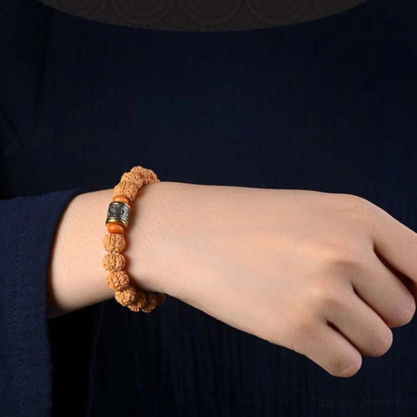 Rudraksha Bodhi seed bracelet worn on adult wrist against dark clothing background showing perfect fit