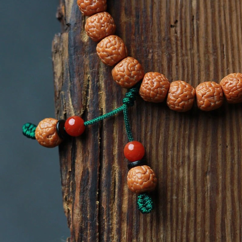 Rudraksha bodhi seed spiritual prayer bracelet with agate tassel and elastic cord detail