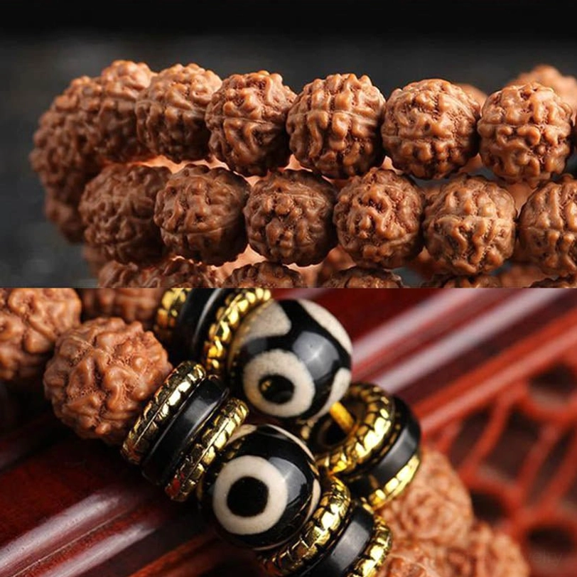 Rudraksha and dzi bead jewelry flat lay showing textured seeds, black dzi spacers with gold trim on wooden surface
