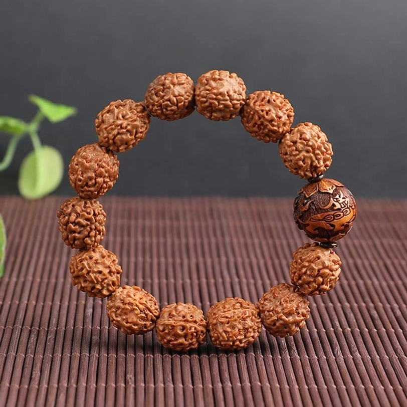 Rudraksha Pixiu bracelet full circle on bamboo woven mat, carved Pixiu accent bead, uniform bead arrangement