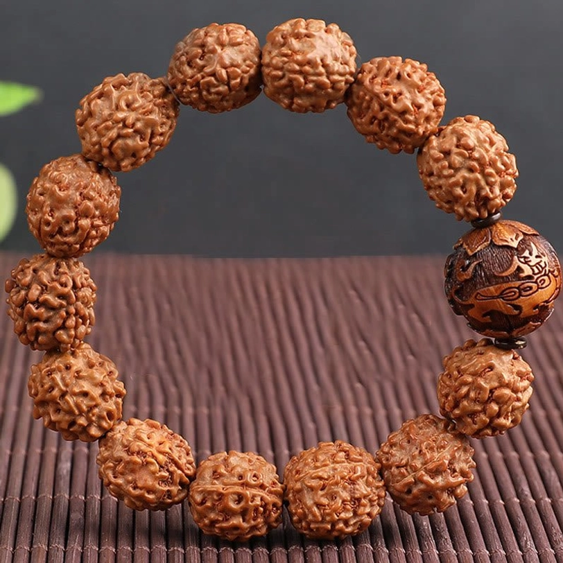 Complete Rudraksha Pixiu wealth bracelet displayed in circle on bamboo mat, carved Pixiu focal bead centered