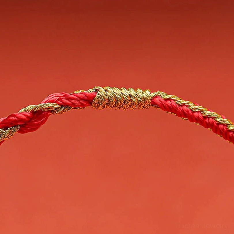 Detailed front view of Tibetan zodiac bracelet gold-wrapped central knot and braided cord