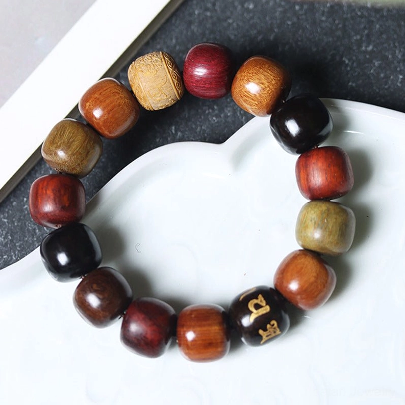 Wooden mala bracelet featuring multicolor barrel beads with black Sanskrit mantra bead on heart-shaped ceramic plate