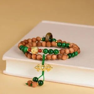 Tibetan protection bracelet displayed on vintage book with gold vajra tassel detail
