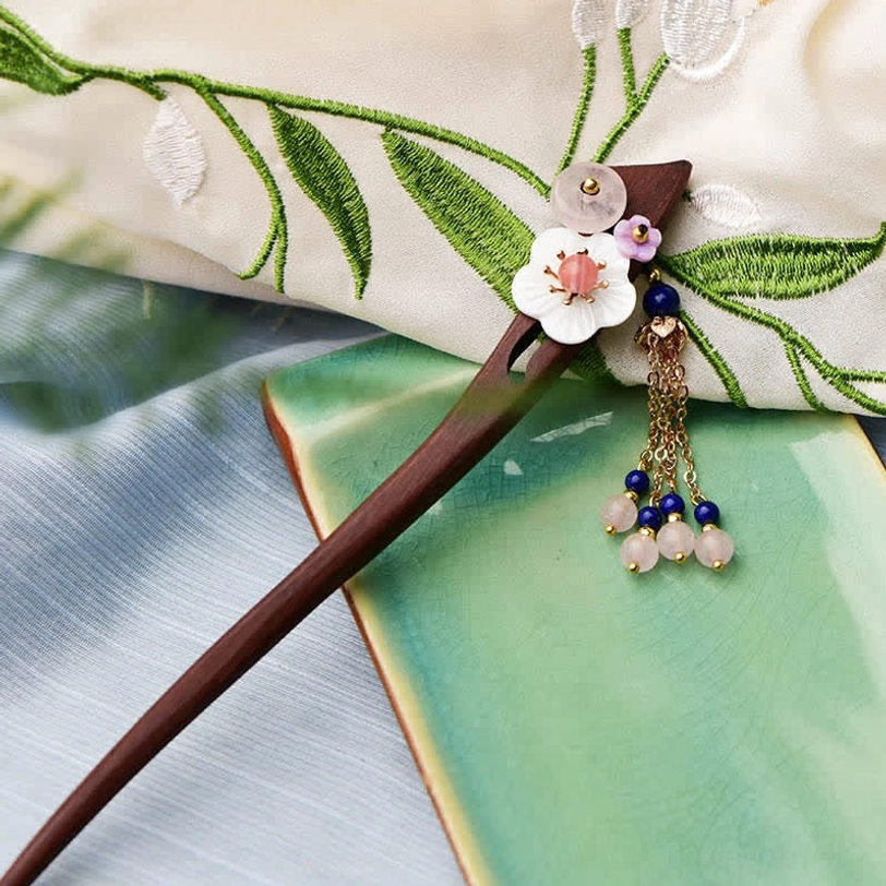 Vintage-inspired wooden hairpin with pink crystal and dangling bead tassel on embroidered fabric