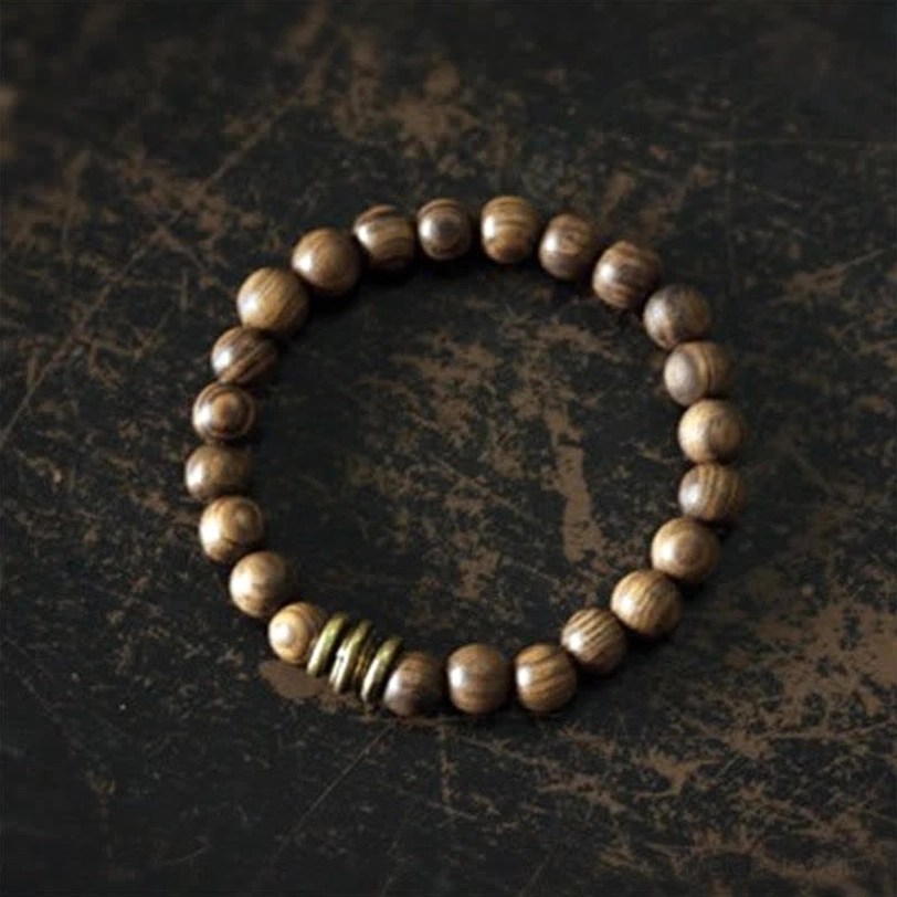 Complete Tibetan sandalwood protection bracelet displayed in circular layout, showing full strand with uniform warm brown tone and bronze hardware details