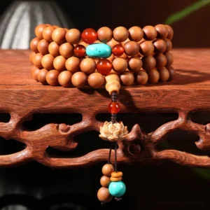 Sandalwood lotus mala bracelet with 108 beads and red turquoise lotus tassel on wooden display stand