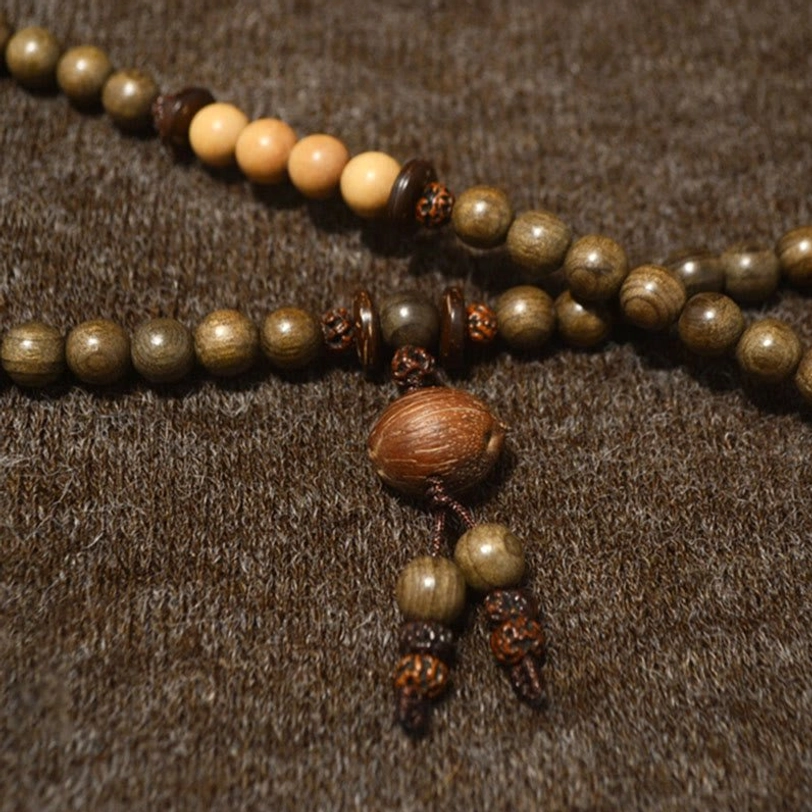 Two-tone Tibetan sandalwood prayer bead mala with alternating light and dark wooden beads and wooden tassel