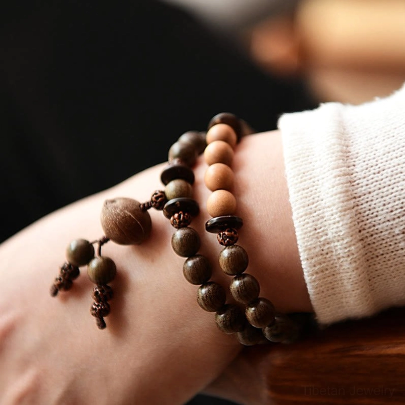 Sandalwood mala bracelet worn on wrist showing natural fit with mixed wood tones and authentic craftsmanship