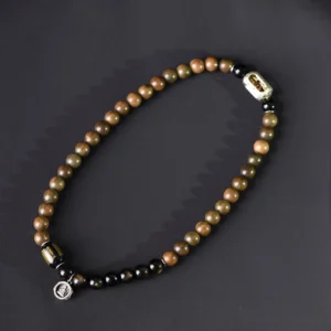 Single strand sandalwood obsidian beaded bracelet flat lay with engraved metal accent bead