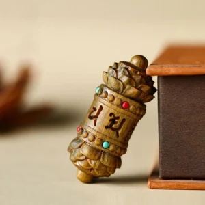 Handcrafted green sandalwood prayer wheel pendant with carved lotus ends and colored gem inlays, side angle close-up detail shot