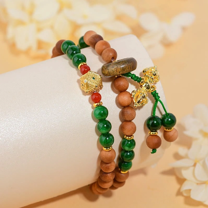 Sandalwood prayer bead bracelet worn on mannequin with gold metal charms and tassel