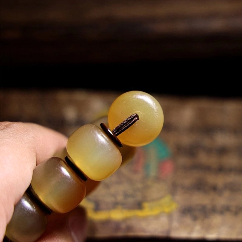 Tibetan sheep horn bracelet segments with barrel beads and metal spacer rings in hand