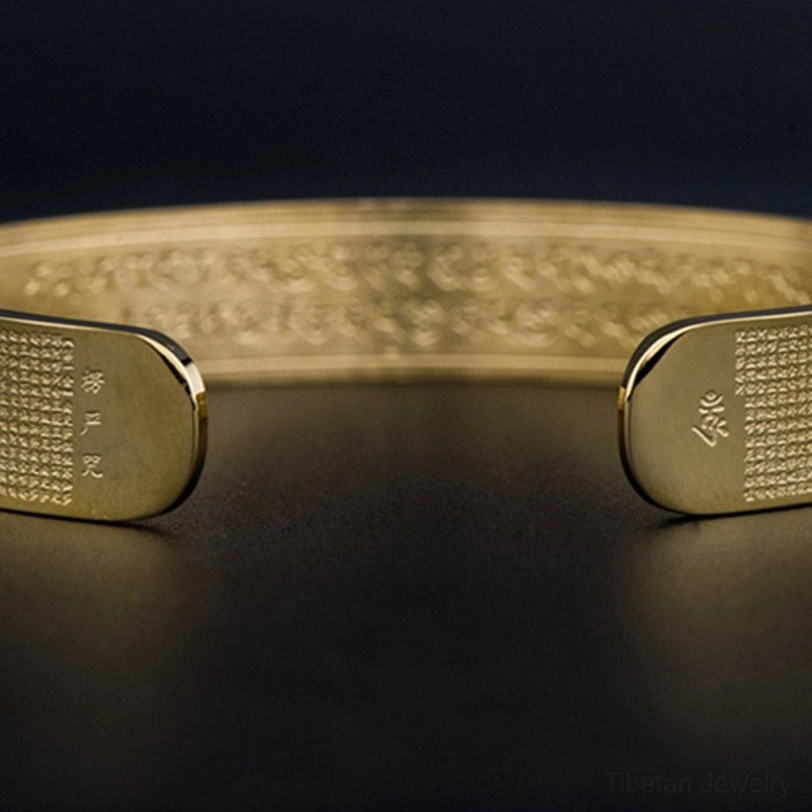 Shurangama mantra titanium steel bracelet end caps - close-up showing engraved sacred symbols and text on the cuff terminals