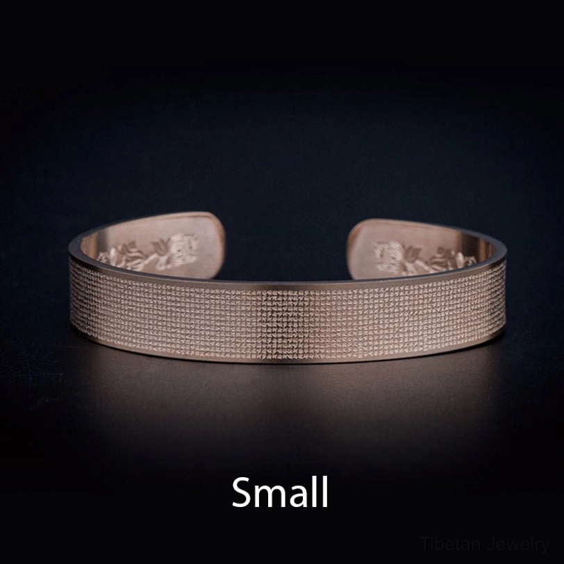 Small Shurangama mantra titanium steel bracelet in peachpuff color - overhead studio view of engraved sacred text