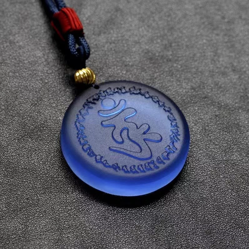 Close-up detail of Shurangama Mantra Liuli crystal pendant showing full engraved Sanskrit mantra pattern and left-side rope cord setup