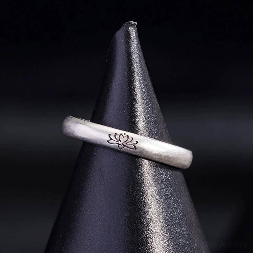 Sterling silver lotus ring front angled view with engraved flower motif on matte finish