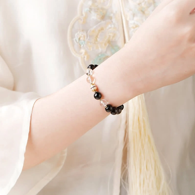 Silver Sheen Obsidian Nine-Eye Dzi Bead Bracelet worn on wrist close-up styling view