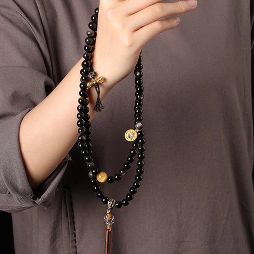 Close-up detail of silver sheen obsidian beads and Garuda metal pendant craftsmanship