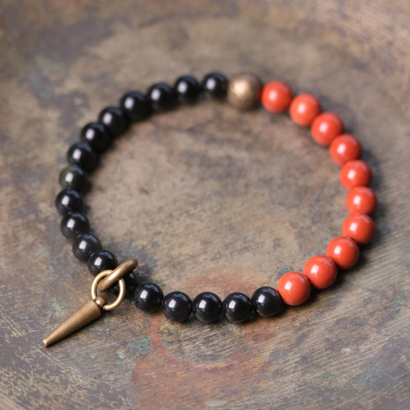 Single black Obsidian and red stone bracelet with copper spike toggle clasp on wooden desk - handmade healing crystal bracelet