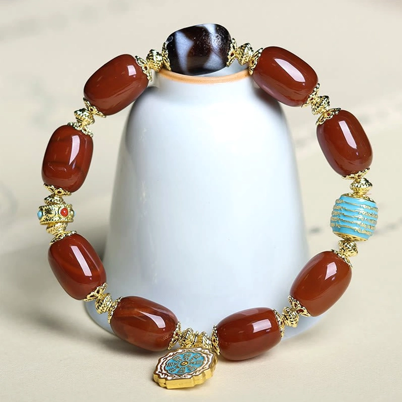 Complete South Red Agate Bagua Dzi Bead Bracelet displayed on white ceramic stand, showing full looped design and enamel charm
