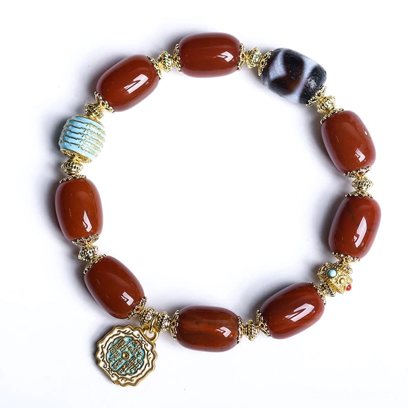 Flat lay of South Red Agate Bagua Dzi Bead Bracelet on plain light background, displaying full bracelet with Bagua pendant charm