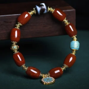 Overhead circular view of South Red Agate Bagua Dzi Bead Bracelet displaying full design with enamel Bagua pendant hanging below